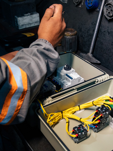 Interior de caixa de controle com cabos amarelos, contatos e disjuntores — inspeção e manutenção de componentes elétricos industriais