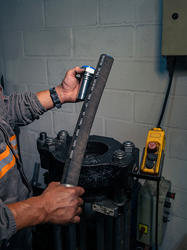 Técnicos analisando planta e medição no local — verificação técnica e planejamento de manutenção hidráulica industrial