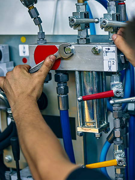 Técnico ajustando válvulas e conexões de sistema pneumático com ferramenta — inspeção e correção de vazamentos em rede de ar comprimido