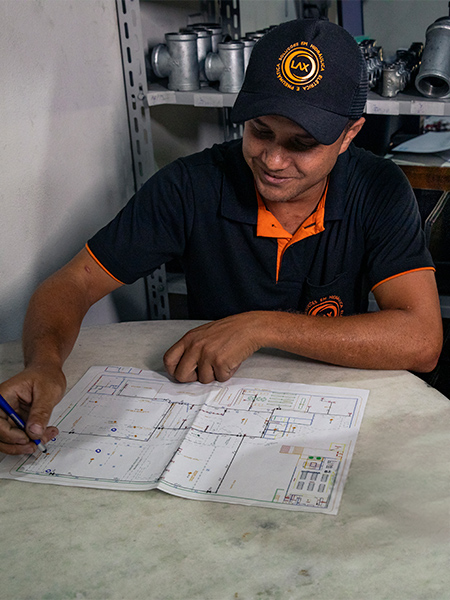 Técnico consultor analisando planta e fazendo anotações durante visita técnica — avaliação e planejamento de rede de ar comprimido