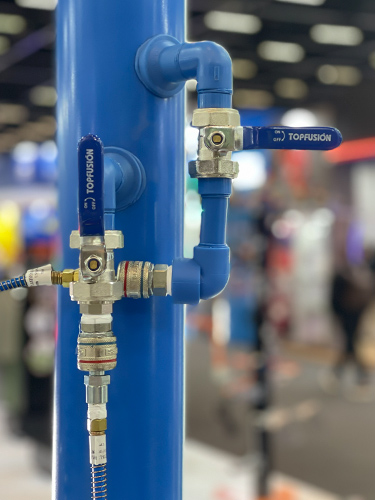 Conexões e mangueiras flexíveis conectadas a manifold amarelo — distribuição e união em rede de ar comprimido industrial